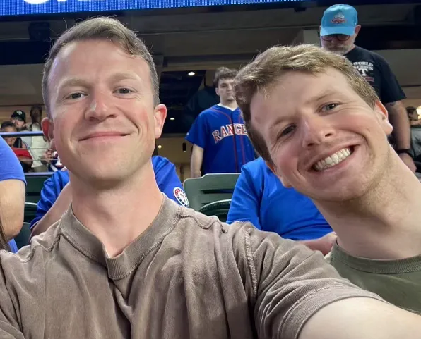 Dan and Jack at a Rangers game, leaning into the camera mid-laugh